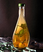 Kumquats and mint leaves with vinegar in bellied bottle