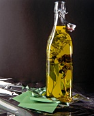 Thyme, sage and marjoram with herb oil in glass bottle