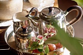 Close-up of silver tea set with wooden handles