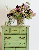 Bouquet of flowers on green chest of drawers