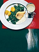 Baltic cod fillet with green cabbage and roasted potatoes on plate