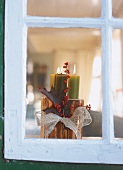 Kerzenständer mit drei grünen Kerzen aus einem Kaminholzscheit