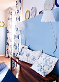 Room with blue painted panels, cushions and fibreboard bench