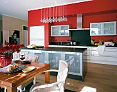 View of red modular kitchen with kitchen block and dining table