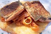 Close-up of brook trout on carrot noodles in chives