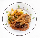 Veal schnitzel with warm potato and truffle salad on plate