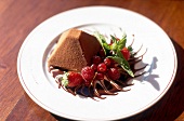 Chocolate pyramid with fresh berries and mint leaves on plate