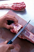 Veal tail being cut on chopping board