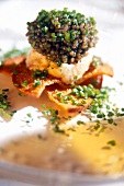 Close-up of caviar with slice of toasted bread and lentils on plate