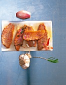 Crispy seared red mullet fillets on tissue with rosemary, thyme and garlic