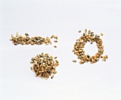 Different shapes made from pumpkin seeds on white background