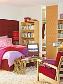 Schlafzimmer mit Bücherregal, Sessel und Fernseher