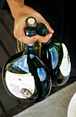Person holding three bocksbeutel wine bottle in Franconia