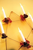 Star shaped candle holders with lit candle and flowers on yellow background