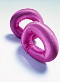 Pink O-rings as additional weights for wrists on white background