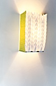 Illuminated paper lamp hanging on white wall