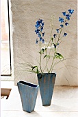 Larkspur flower in blue vase on floor