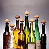Variety of vinegar, wine and oil bottles with handmade wooden cooks on it