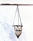 Close-up of light brown oriental style suspension lamp against white background