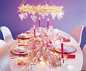 Festlich gedeckter Tisch mit Weihnachtskugeln und Kerzen