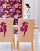 Two chairs at dining table and floral pattern wallpaper in dining room