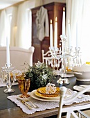 Festive table laid with candle holders and glass plates in dining room