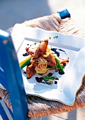 Close-up of chicken teriyaki on white plate on a garden chair