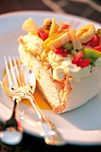 Ein Stück Meringue-Torte "pavlova", mit Kiwi- und Bananenscheiben