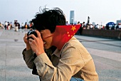 Shanghai - Mann mit rotem Halstuch macht vergnügt ein Foto