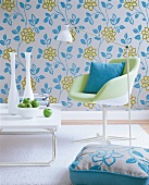 Room with floral wallpaper, chair, cushion, table and bowl of apple