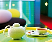 Teatime: weiße Teekanne mit Tasse Tee