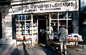 Customer buying books outside Library Albert Blanchard in Paris, France