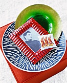 Sachets, picture frame and ceramic bowl on dinner plate