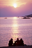 Korsika, Menschen am Strand genießen einen Sonnenuntergang