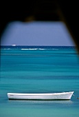 Weiter Blick über das Meer mit weißem Ruderboot vor Mauritius