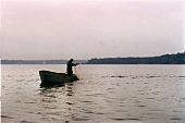Fischer im Fischerboot zieht das Netz aus dem Wasser