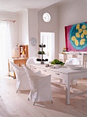 View of dinning room with table, lord yo chair and red and blue painting on the wall