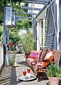 Outside terrace with floating wooden swing, pot plants and drinks in tray