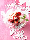 A glass bowl of strawberries and yogurt with rhubarb syrup