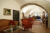 Interior of hotel with stone arch, sofa and chair, Austria