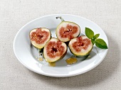 Halved figs with sherry vinegar and honey on plate