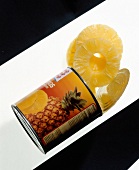 Opened tin with pineapple on white background