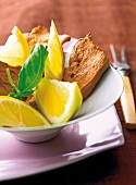 Smoked chicken with lemon wedges in bowl