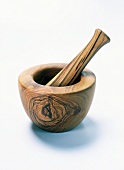 Close-up of mortar and pestle made up of olive wood on white background