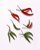 Red and green chilli peppers on white background