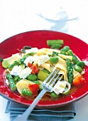 Pasta with peas, asparagus and cheese served on plate