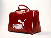 Red leather sports bag of Puma on white background