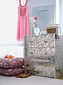 Drawer chest covered with silver wallpaper and tendril pattern with cushion and sandals