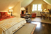 Interior of bedroom with bed, cushion, side lamp, chairs and table in hotel, Switzerland