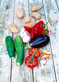 Fresh tomatoes, eggplant, zucchinis, onions and potatoes on wooden surface